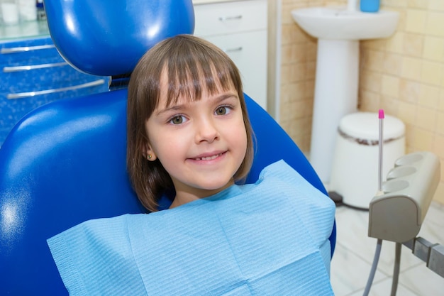 Uma criança está sentada em um consultório de dentista