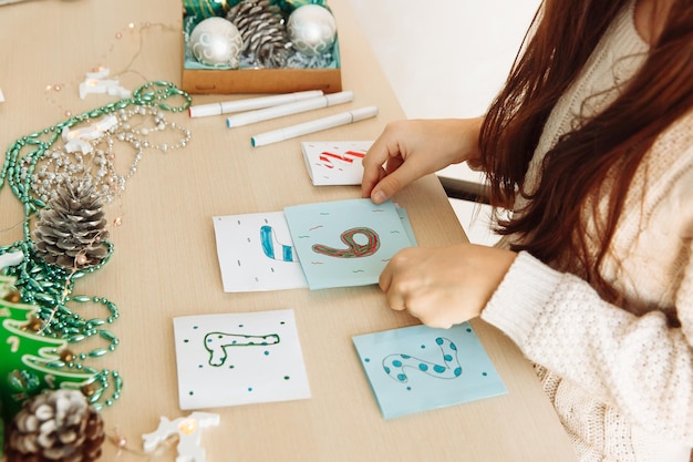 Foto uma criança faz um calendário do advento de natal em papel com as próprias mãos faça você mesmo de perto