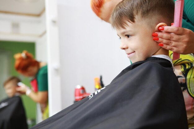 Foto uma criança feliz está sentada numa barbearia.