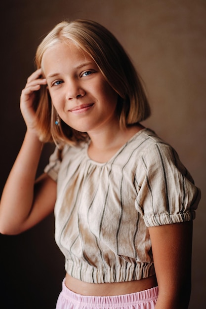 Foto uma criança feliz, uma menina com uma camiseta cinza sobre fundo bege