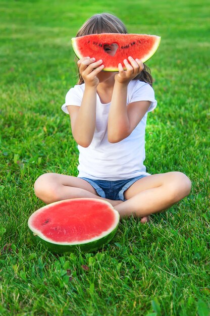 Uma criança fofa comendo melancia