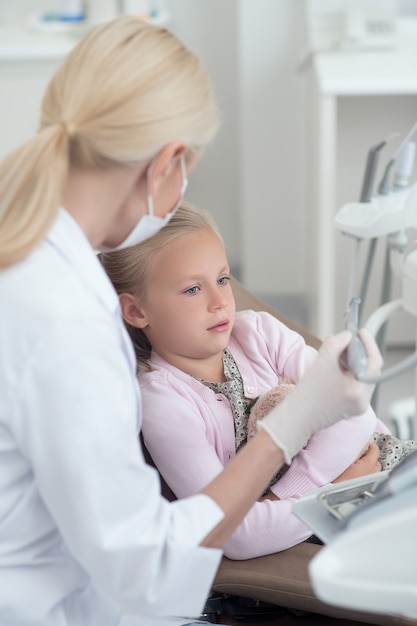 Uma criança loira fazendo tratamento dentário no dentista