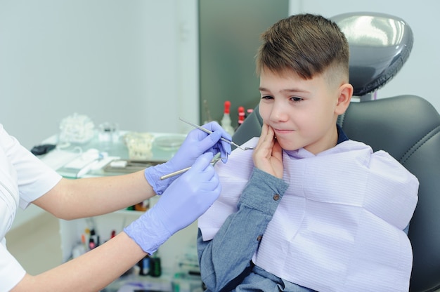 Uma criança menino com um dentista em um consultório odontológico