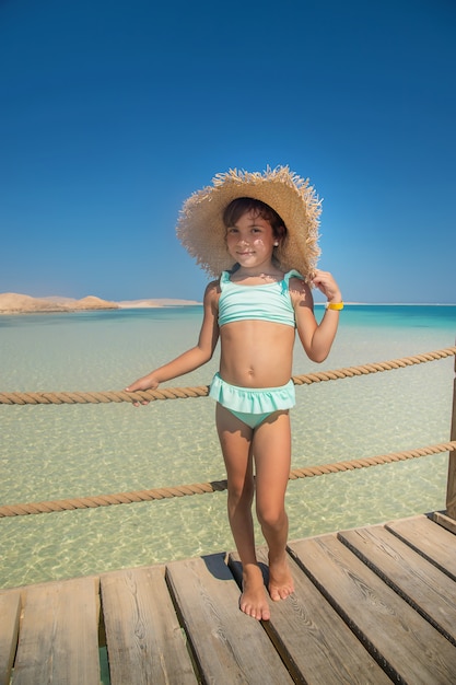 Uma criança na praia perto do mar.