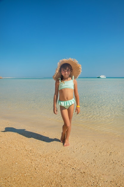 Uma criança na praia perto do mar.