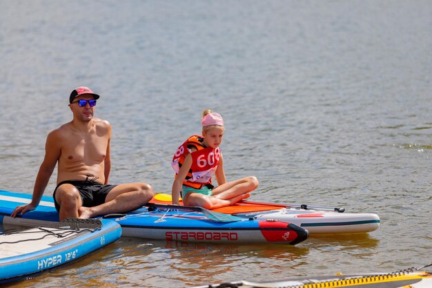 Uma criança nada em uma prancha de surf empurrando com um remo Paddleboarding