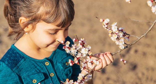 Uma criança no jardim de árvores floridas Foco seletivo