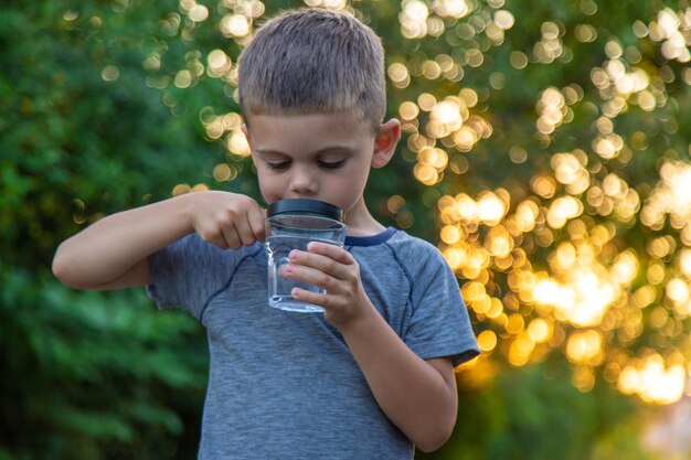 Foto uma criança olha para a água através de uma lupa foco seletivo natureza