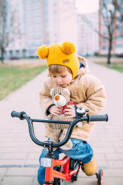 uma criança pequena aprende a andar de bicicleta pela primeira vez na cidade na primavera