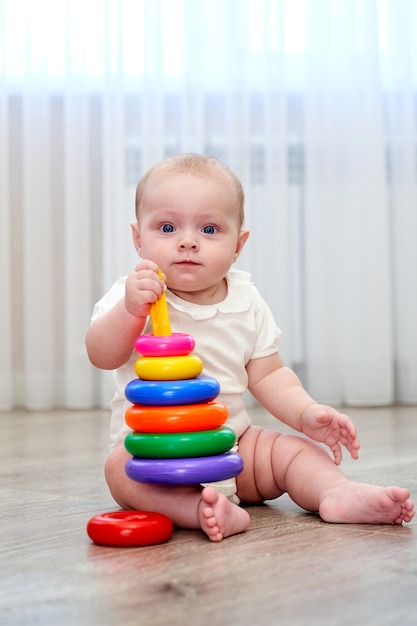 Uma criança pequena com blua criança pequena com olhos azuis está brincando na sala de jogos e os olhos estão brincando na sala de jogos