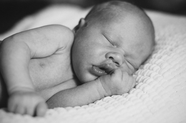 Foto uma criança pequena, de duas semanas de idade, dorme em uma cesta sobre um cobertor de lã