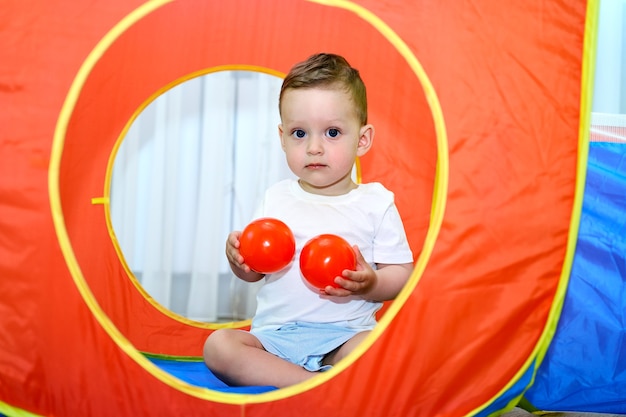 Foto uma criança pequena de olhos azuis está brincando na sala de jogos.