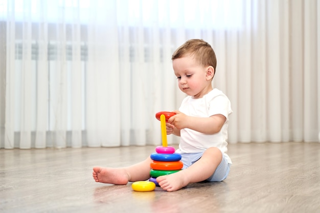 Uma criança pequena de olhos azuis está brincando na sala de jogos.