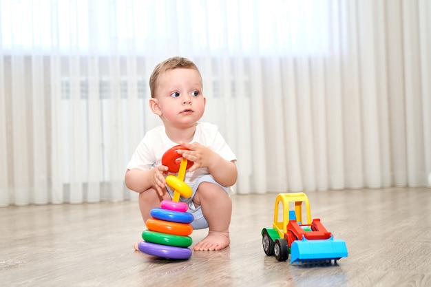 Uma criança pequena de olhos azuis está brincando na sala de jogos.