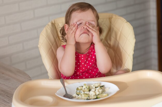 Uma criança pequena não quer comer lasanha com legumes e é safada