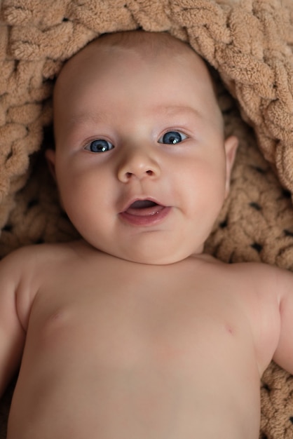 Foto uma criança pequena, um bebê deitado nu e sorrindo