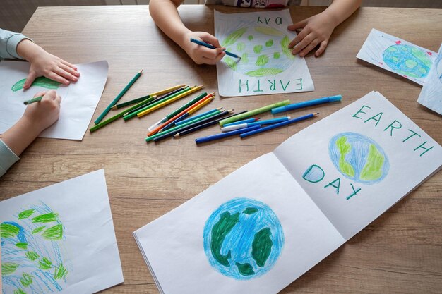 Uma criança se senta em uma mesa com um desenho da terra e as palavras dia da terra.