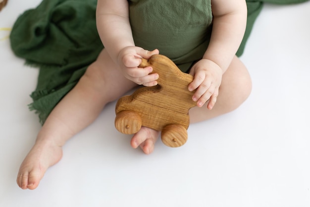 uma criança segura um brinquedo de madeira lebre de brinquedo de madeira