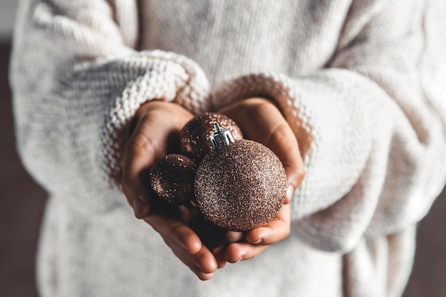 Uma criança segurando uma bola vermelha de Natal. Design de cartão de Natal. Copie o espaço. Fechar-se