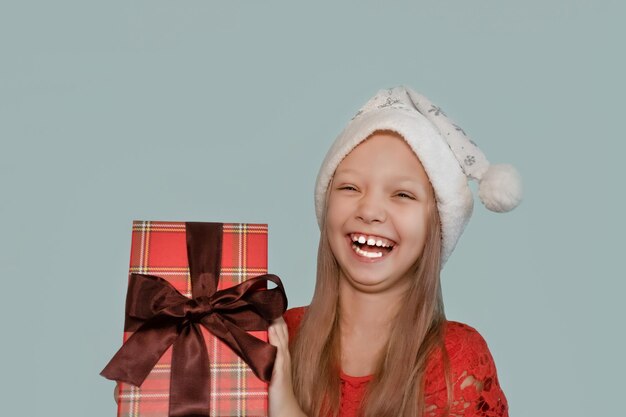 Uma criança sorridente com um presente de Natal nas mãos Feriados e eventos Natal