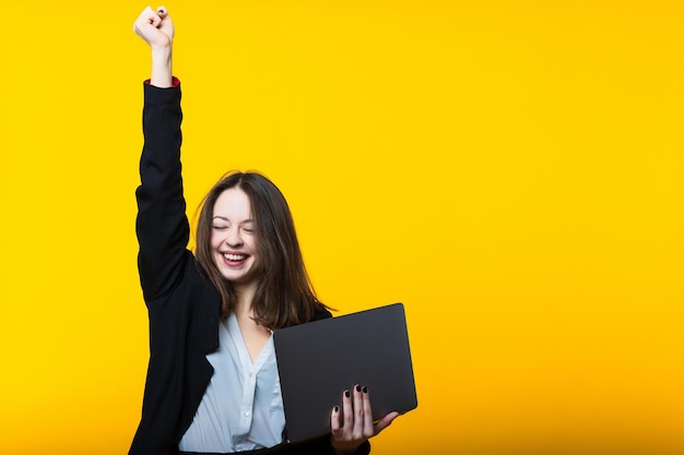 Uma decisão bem-sucedida nos negócios Retrato de uma jovem com um laptop em um fundo amarelo