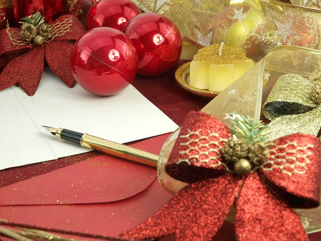 Uma decoração de natal vermelha com uma carta e uma fita vermelha