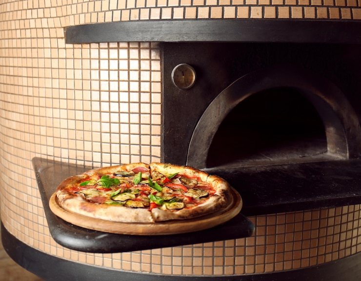 Foto uma deliciosa pizza assada perto do forno.