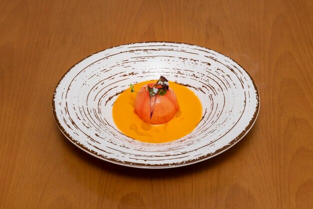 Uma deliciosa receita de tomate recheado servido em um restaurante em pratos brancos e com mesas de madeira