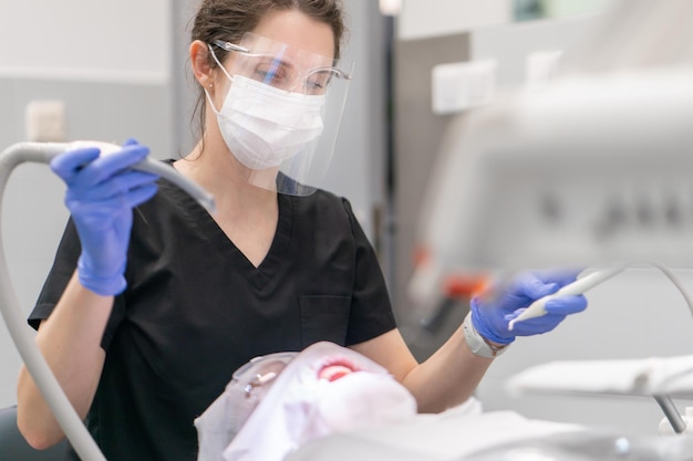 Uma dentista feminina começa a receber um paciente em um consultório odontológico