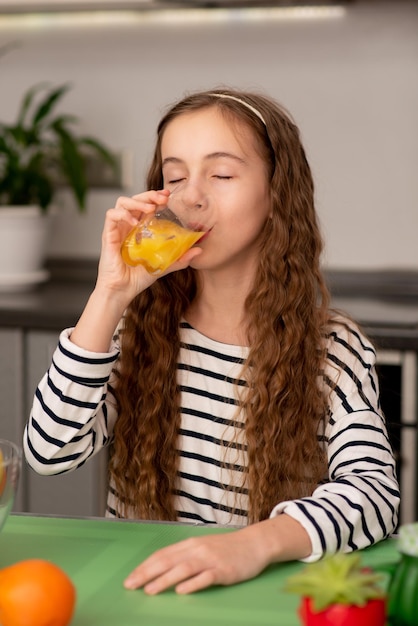 Uma doce adolescente bebe uma laranja fresca Alimentação saudável Família Frutas frescas