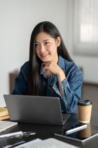 Uma empresária asiática atraente e confiante está ouvindo as ideias de sua equipe durante a reunião