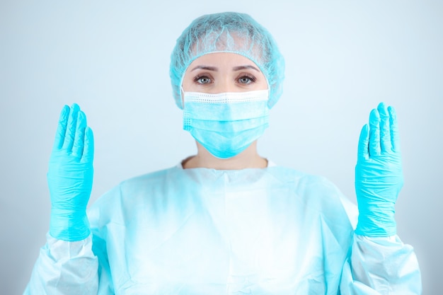 Uma enfermeira com bata e máscara médica ergueu as mãos