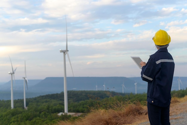 Uma engenheira está usando um capacete protetor na cabeça usando o tablet Analytics