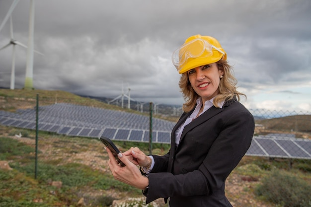 Uma engenheira usa seu smartphone no trabalho em uma usina de energia solar