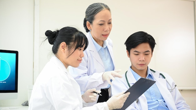 Uma equipe de cientistas asiáticos profissionais discutindo sobre sua pesquisa de experimentos farmacêuticos