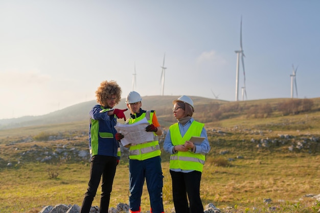 Uma equipe de engenheiros e trabalhadores supervisiona um projeto de turbina eólica em um moderno parque eólico trabalhando