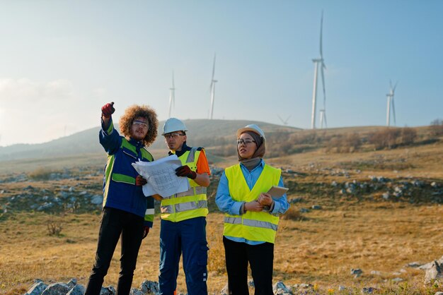 Uma equipe de engenheiros e trabalhadores supervisiona um projeto de turbina eólica em um moderno parque eólico trabalhando