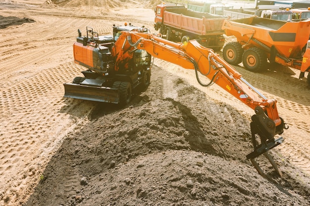 Uma escavadeira em um canteiro de obras planeja o terreno antes de trabalhar na fundação