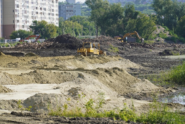 Uma escavadora nivela a areia na costa do rio Sviyaga Reconstrução da costa