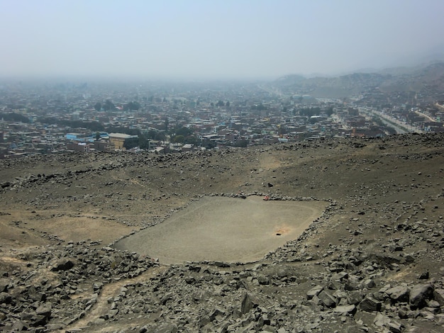 Uma esplanada deserta entre colinas ao longe Uma cidade entre colinas.