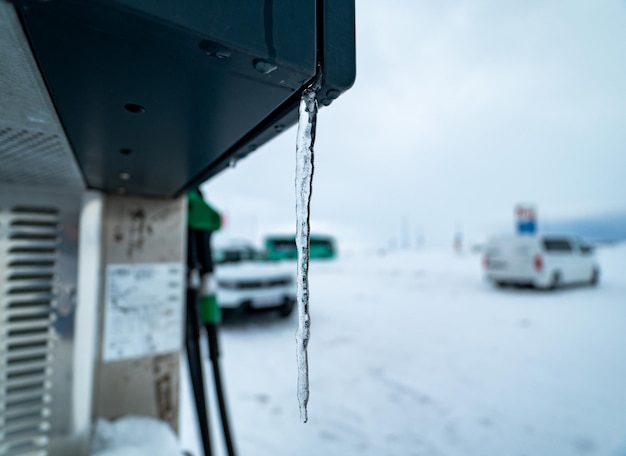 Uma estalagmite de gelo ao lado de uma mangueira de reabastecimento de gasolina ou diesel em um posto de gasolina na Islândia