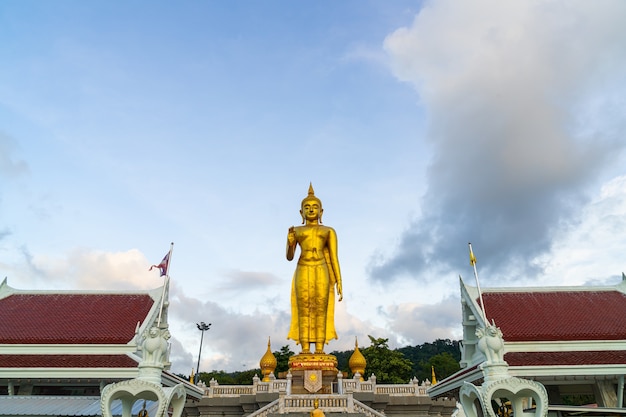 Uma estátua de Buda dourado com céu no topo da montanha no parque público do município de Hat Yai, província de Songkhla, Tailândia