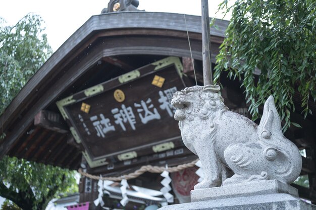 Uma estátua de leão de pedra fica em frente a um prédio com uma placa que diz 'o ano da cabra'.