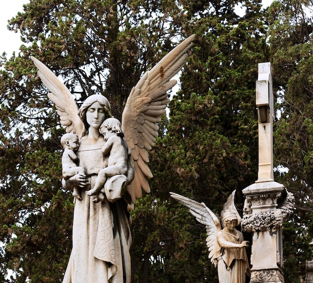Uma estátua de um anjo com dois anjos nela