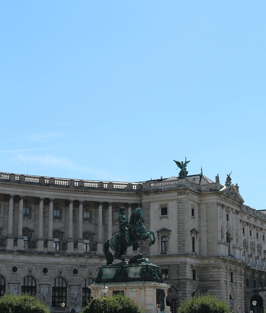 Uma estátua de um homem a cavalo fica em frente a um prédio.