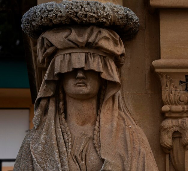 Uma estátua de uma mulher com um chapéu na cabeça