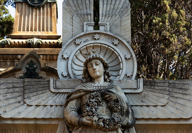 Foto uma estátua de uma mulher com uma coroa de flores na cabeça é cercada por uvas.