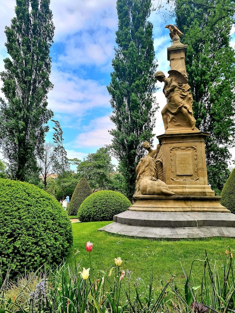 Uma estátua em um parque com uma estátua de uma mulher e um homem no topo.