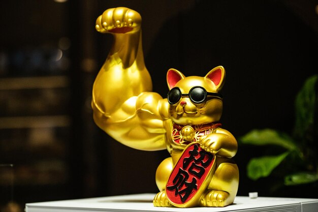 Uma estatueta de gato de ouro com as letras'cat'on