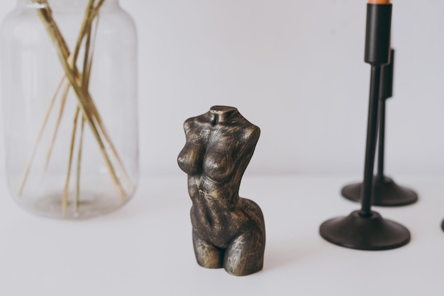 Foto uma estatueta de pedra com a forma de uma figura feminina está sobre a mesa como decoração